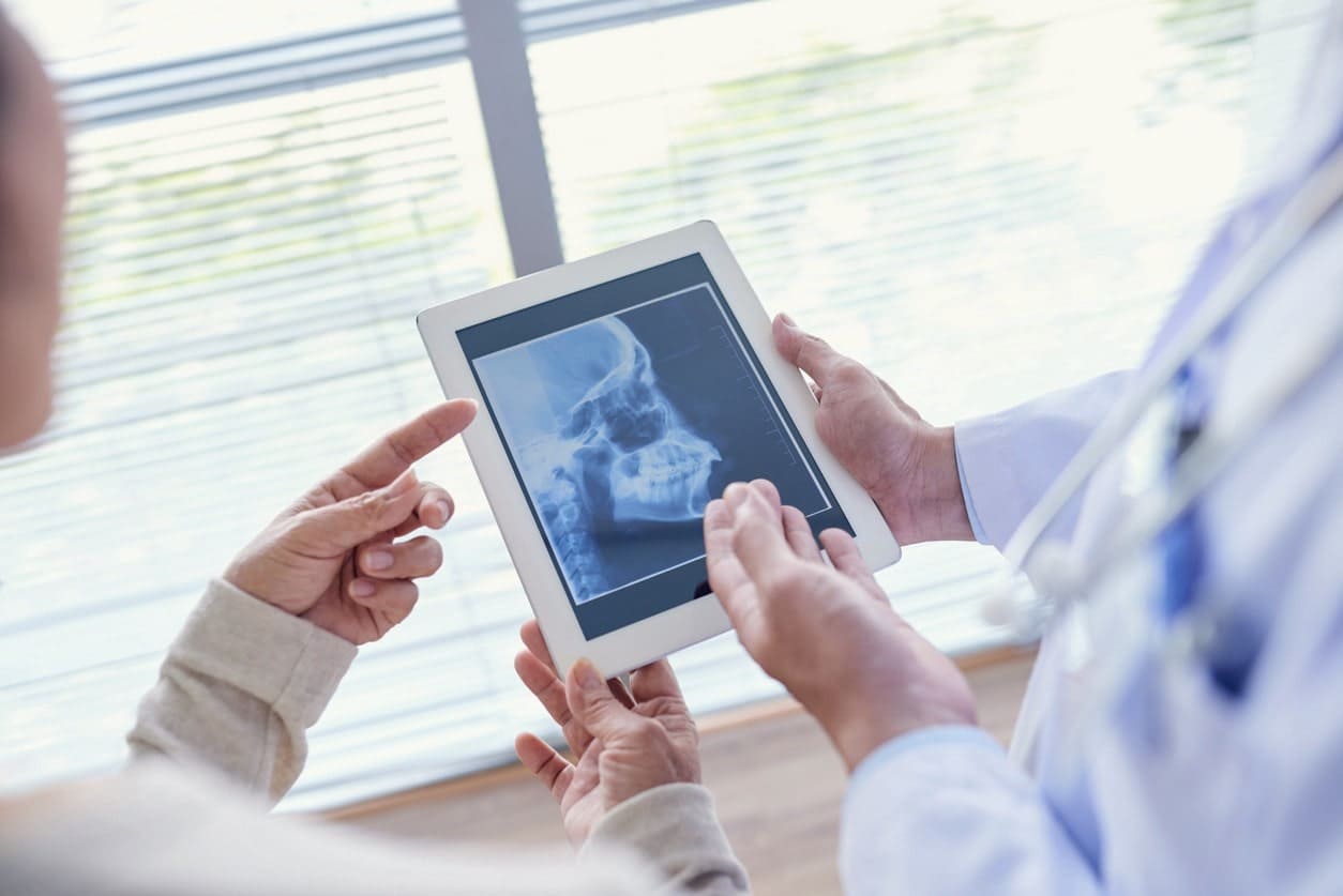dentist and patient looking at x ray