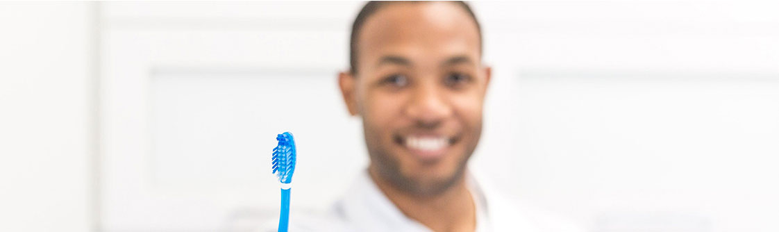 dentist holding a toothbrush in dental office