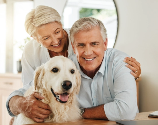 Senior couple with their dog, the couple is smiling about affordable senior dental insurance